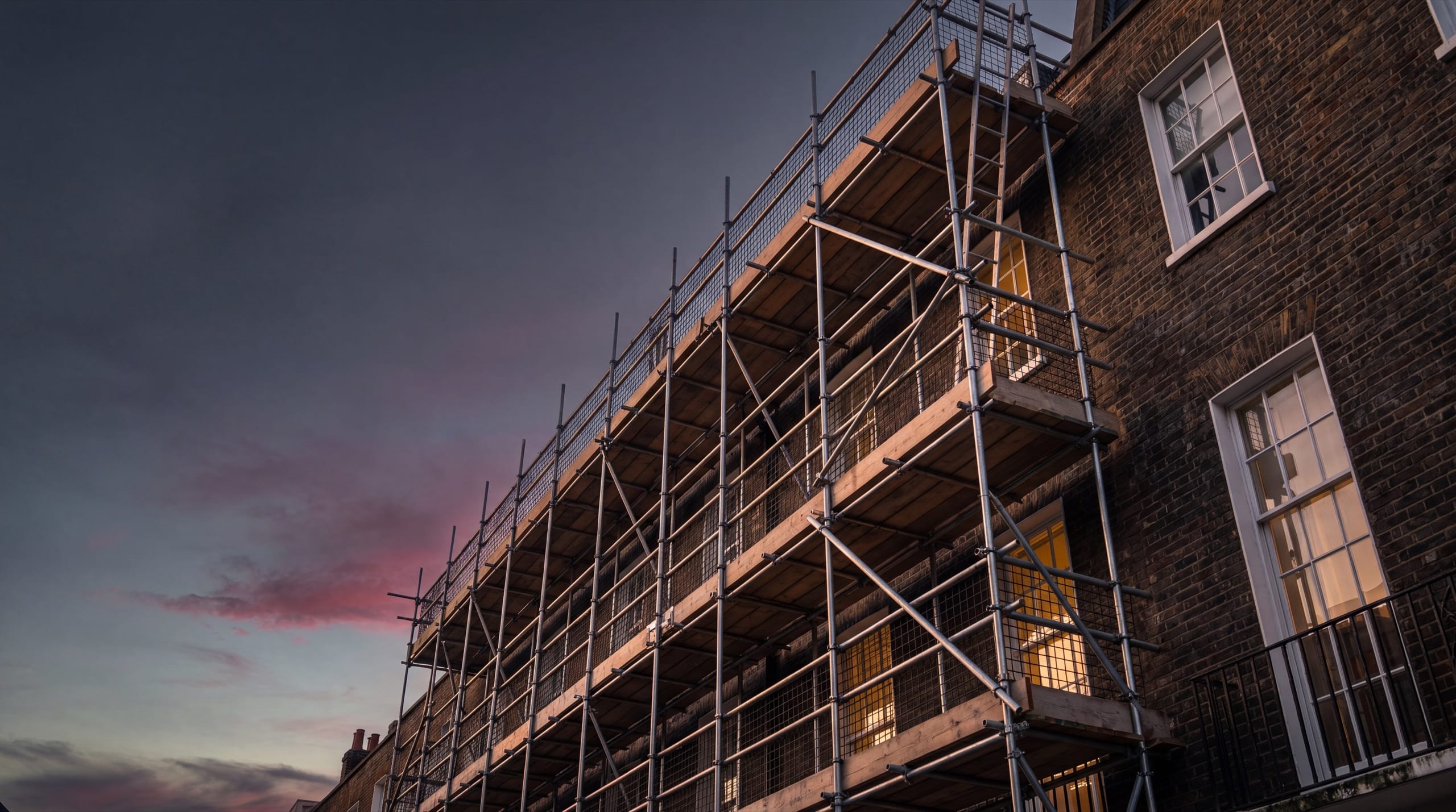 Multi-storey residential scaffolding erected by Rocket Scaffolding in Surrey at dusk